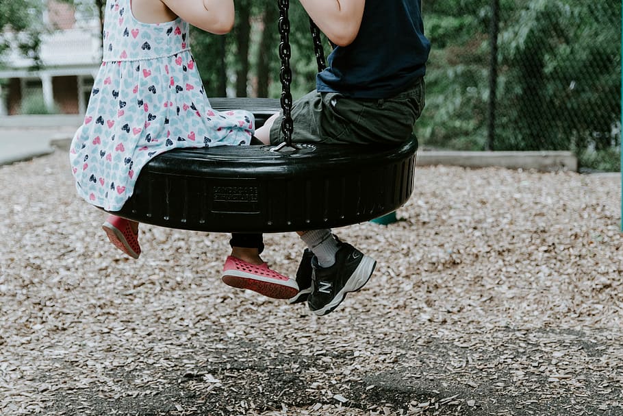 two children playing on tire swing, children riding on blue wheel swing HD wallpaper