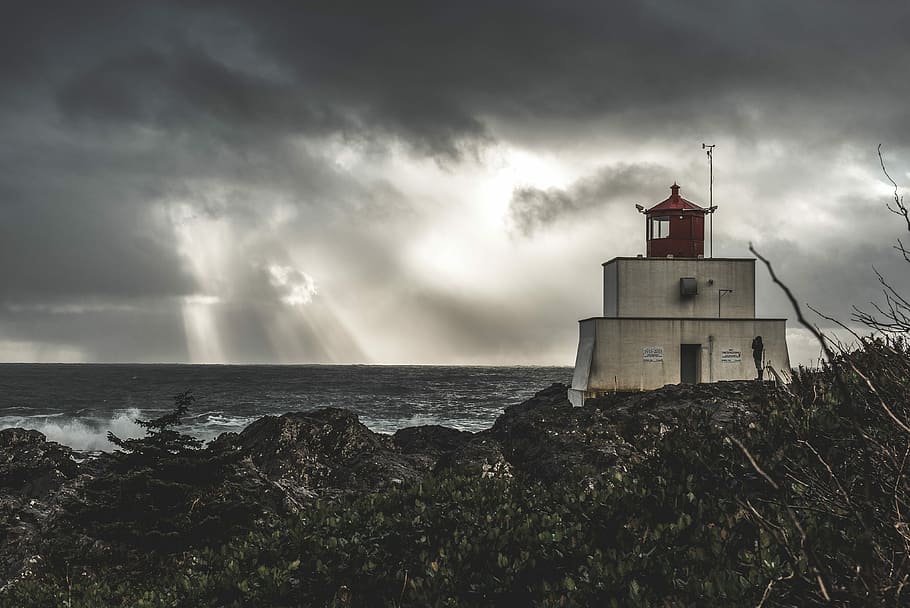house near body of water during crepuscular rays, storm, lighthouse HD wallpaper