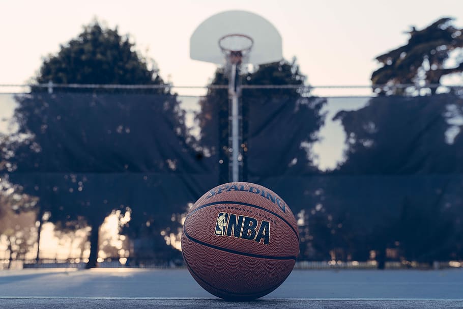NBA Spalding ball, brown NBA basketball near hoop during daytime