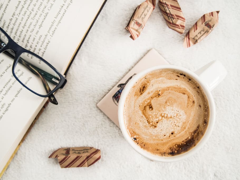 cup of coffee beside book with black framed eyeglasses, reading HD wallpaper