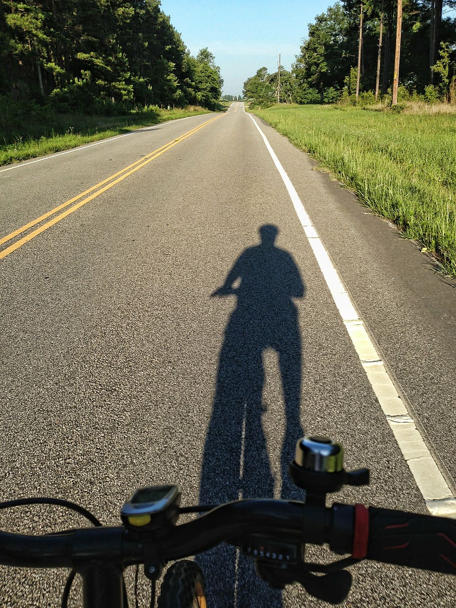 person biking on road beside tree, shadow of cyclist, rural road, HD wallpaper