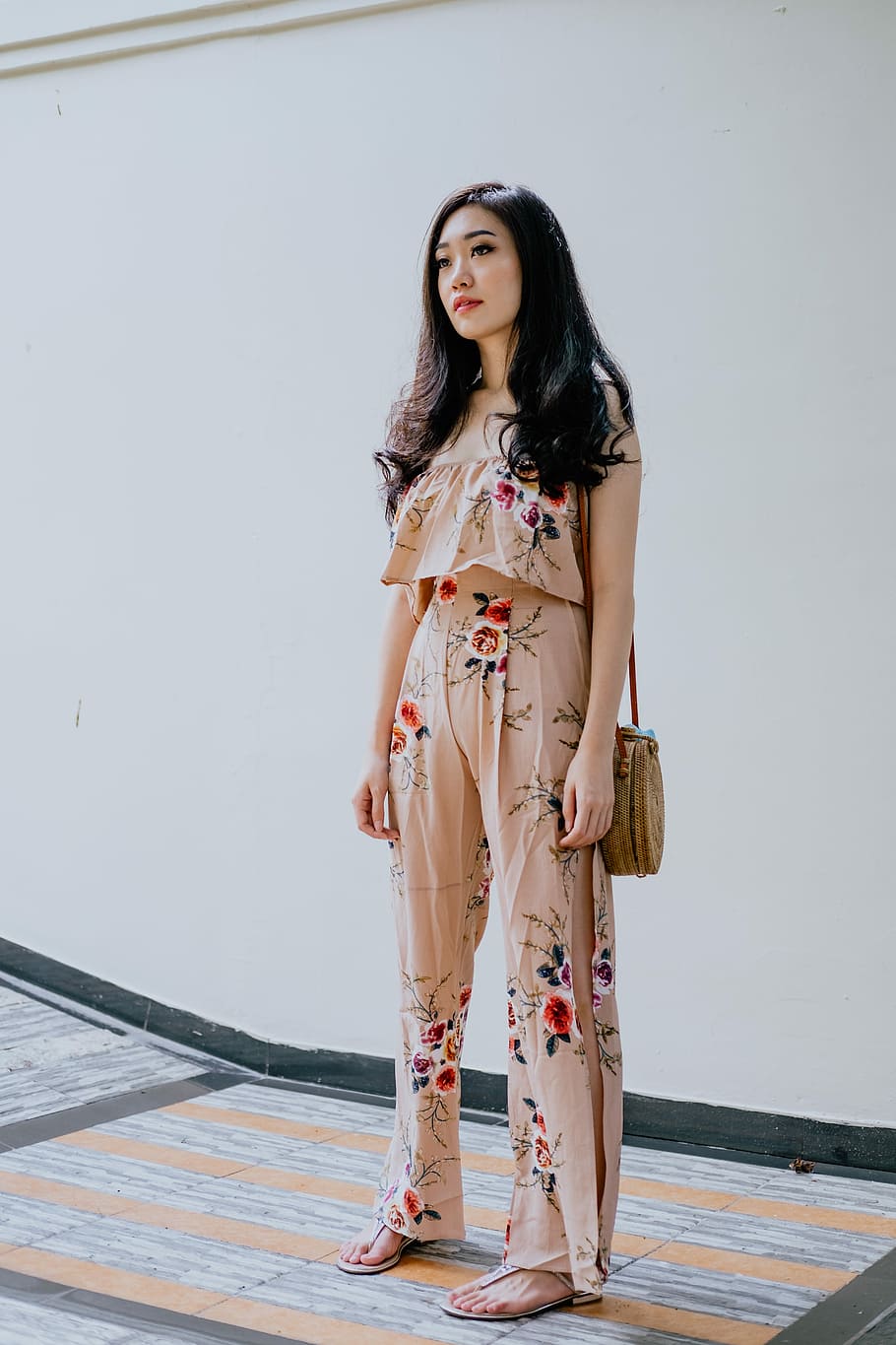 woman wearing beige-and-red floral crop top with pants, woman standing near white painted wall, HD wallpaper