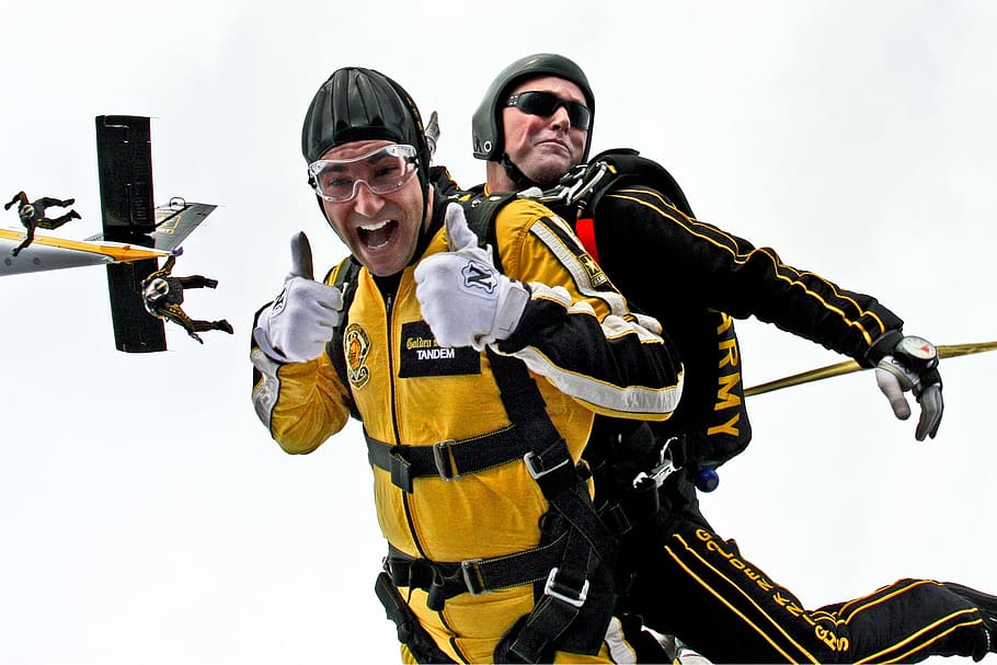 two men wearing black and yellow safety suits, tandem skydivers HD wallpaper