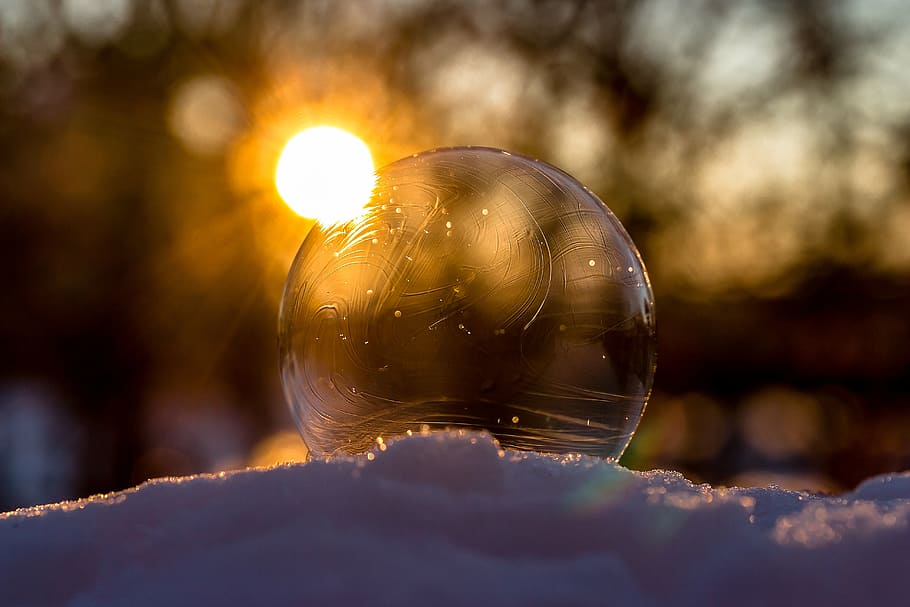 clear ball on snow, frozen bubble, soap bubble, slightly frozen