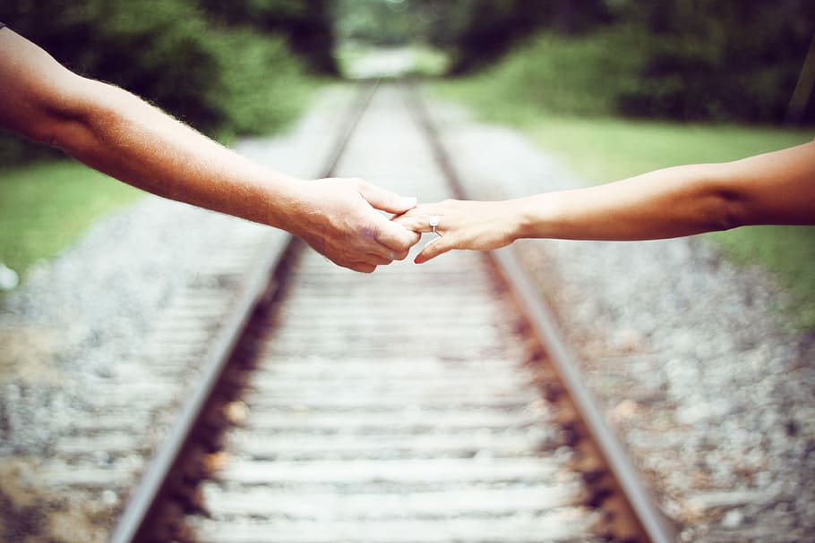two persons holding each other, selective focus photography of two person holding hands HD wallpaper