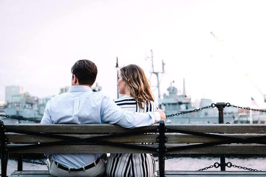 couple sitting on bench near body of water, man and woman sitting on bench HD wallpaper