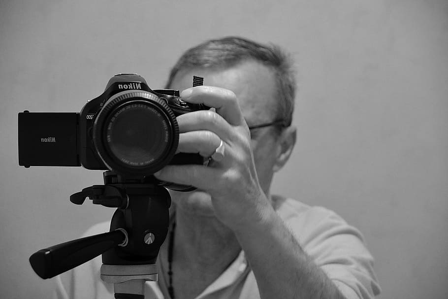 grayscale photography of man holding Nikon DSLR camera, picture HD wallpaper