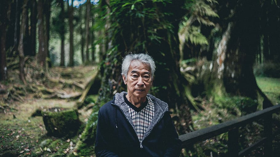 man wearing jacket neat tree outdoor, man standing in woods, portrait HD wallpaper