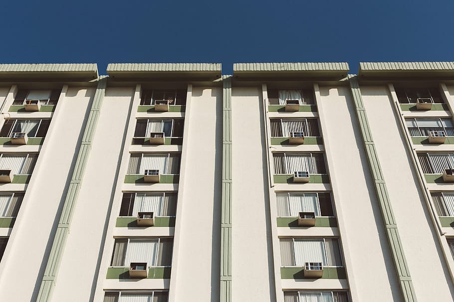 white painted apartment under clear blue sky during daytime HD wallpaper