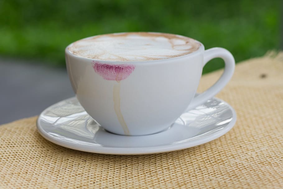 selective focus photography of white ceramic cup with cappuccino