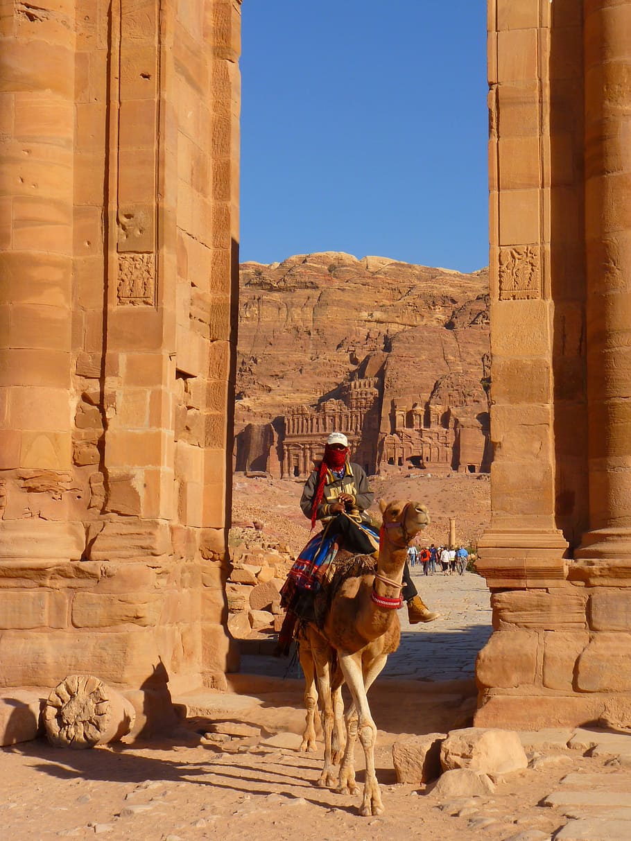 man riding camel by near arch, Petra, Jordan, Holiday, Travel