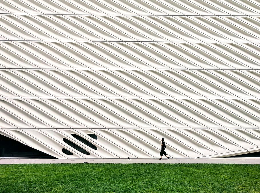 person walking on concrete pathway, man walking near grass field HD wallpaper