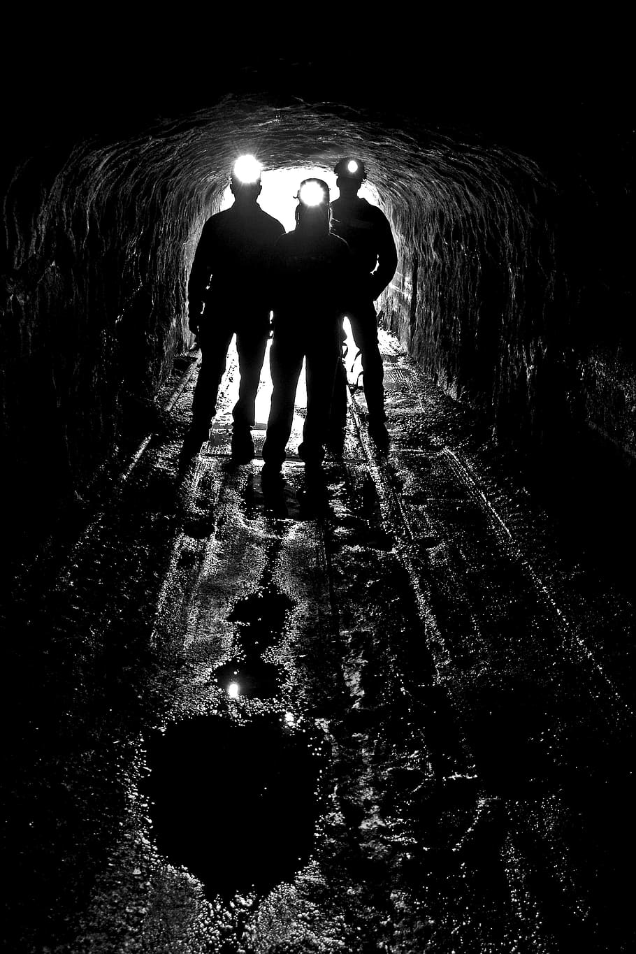 silhouette of three person on cave with headlamp, silhouettes