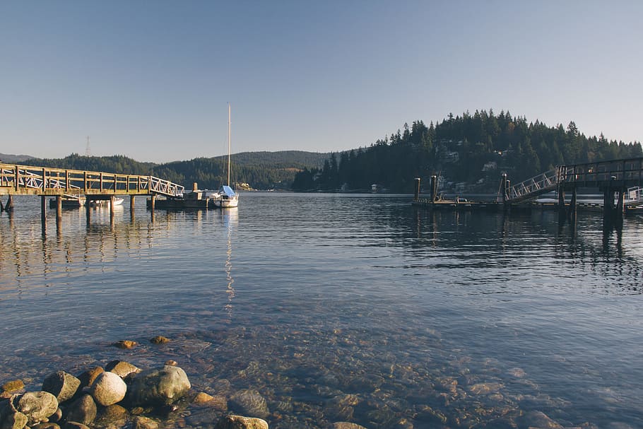body of water with wooden docks during daytime, boat beside dock during daytime HD wallpaper