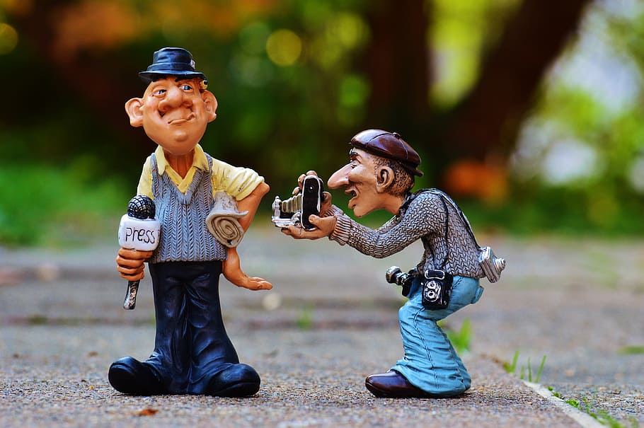 shallow focus photography of two men plastic toys, press, journalist