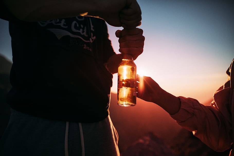 person holding glass bottle, man holding glass bottle near woman HD wallpaper