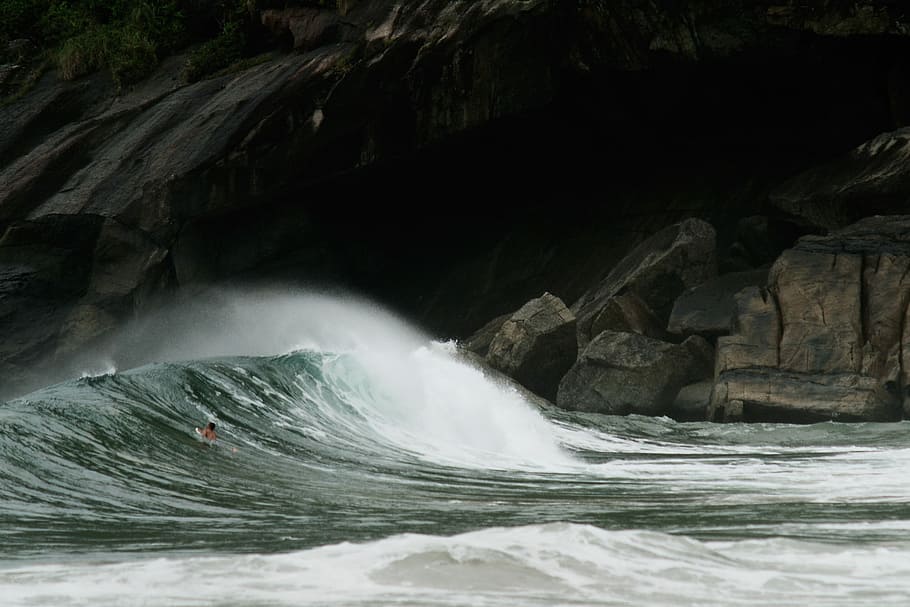 Surfing wave, ocean wave hitting rocky shore, water, crash, green