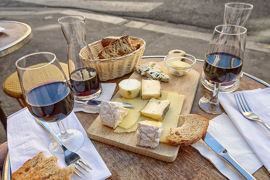 clear short-stemmed wine glasses, sliced breads, brown wooden chopping board, and brown wicker basket on brown wooden table HD wallpaper