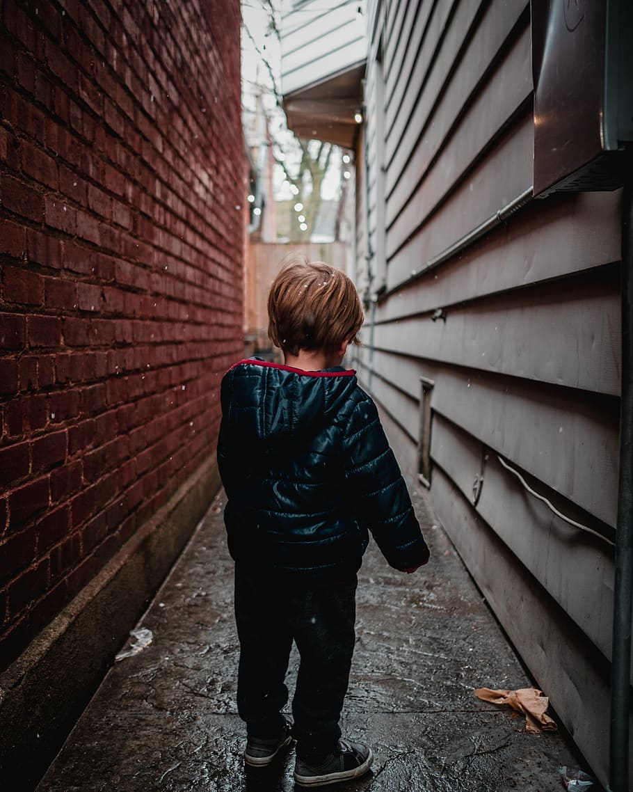 shallow focus photography of toddler in alley, boy standing in middle of alleyway, HD wallpaper