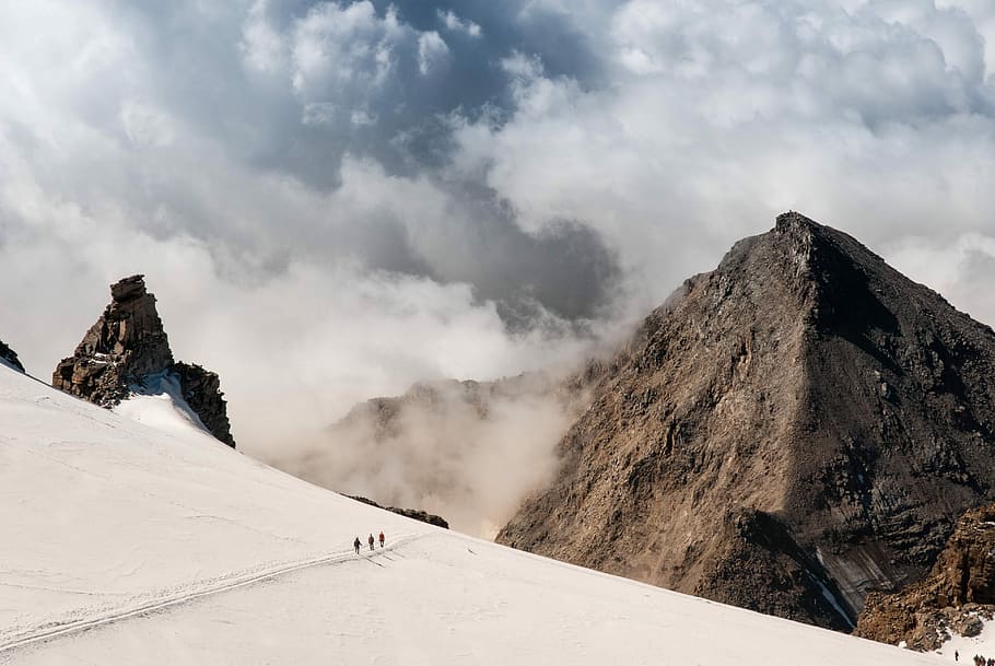people walking on mountain alps with clouds, aerial photo gray sand near mountain range HD wallpaper