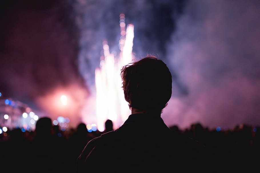 man facing on fireworks, man standing watching fireworks during nighttime HD wallpaper