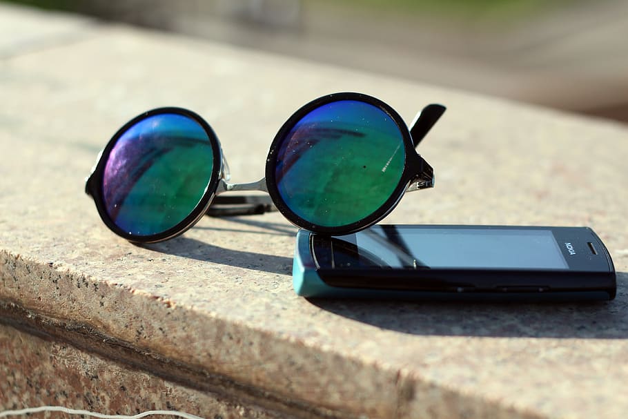 black framed hippie sunglasses beside black Android smartphone on top gray concrete surface, HD wallpaper