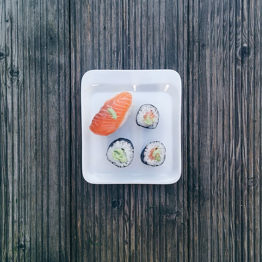 Minimal sushi on wooden background, maki, nigiri, rice, salmon