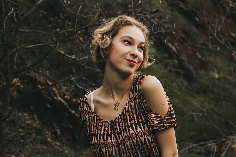 woman wearing brown shirt near leafless tree trunk, woman in brown and black tribal cold-shoulder top HD wallpaper