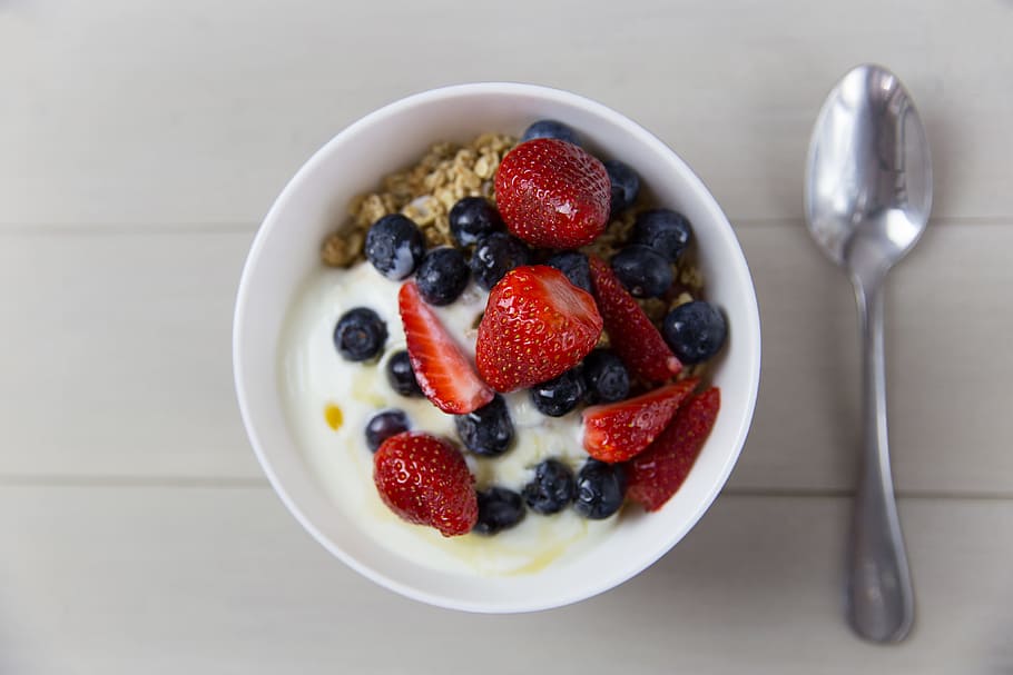 Bowl of yogurt, strawberries, blueberries and granola breakfast cereal with spoon, HD wallpaper