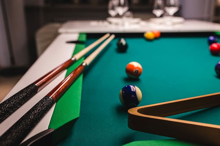 Billiard balls on green table with billiard cue, nobody, time