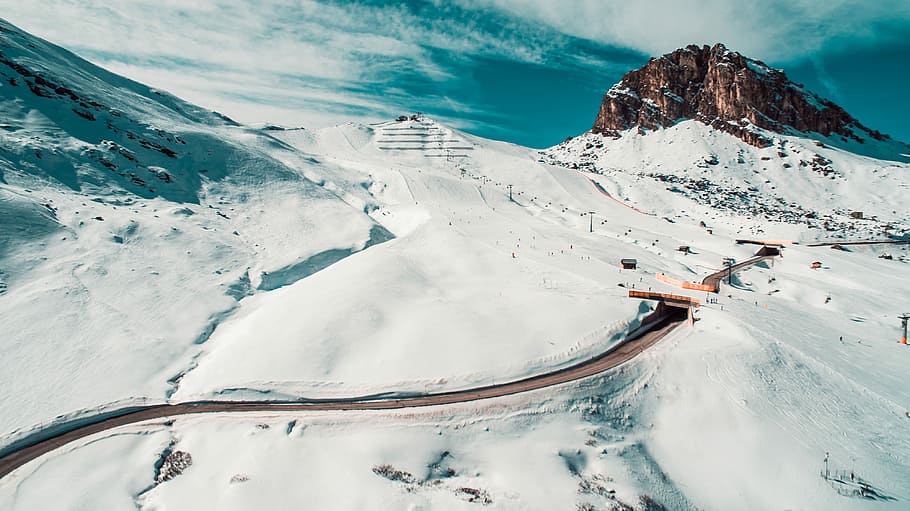aerial view of road surrounded by mountain covered by snow, snowy mountain with zigzag road HD wallpaper