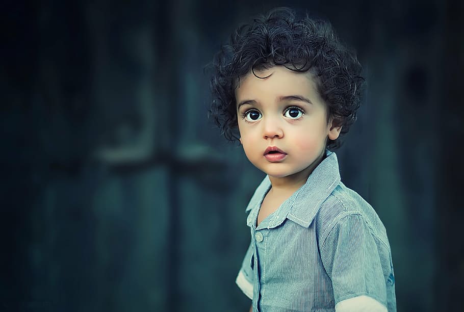 selective focus photo of a boy wearing blue button-up shirt, child