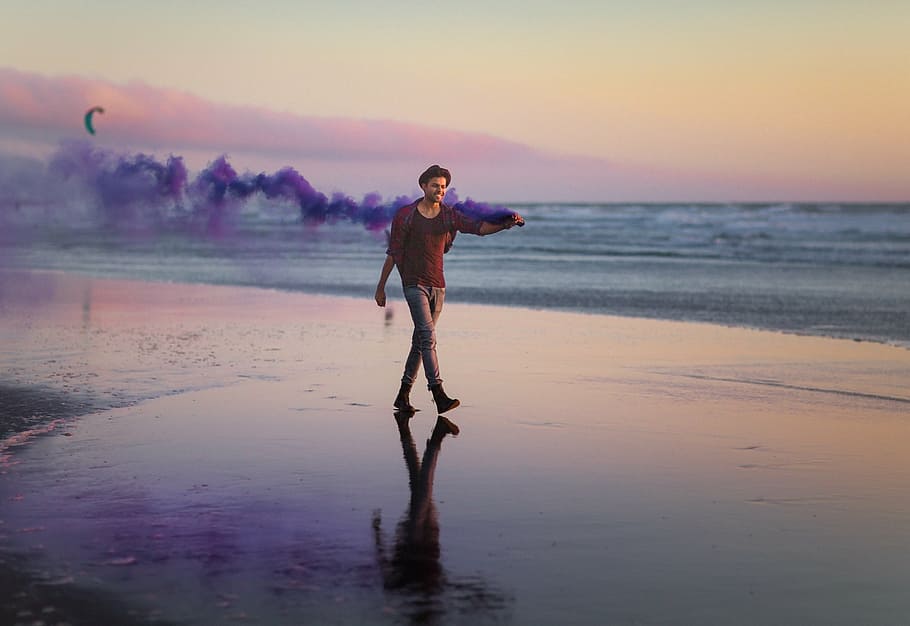 man walking on seashore while holding smoke machine, daytime, HD wallpaper