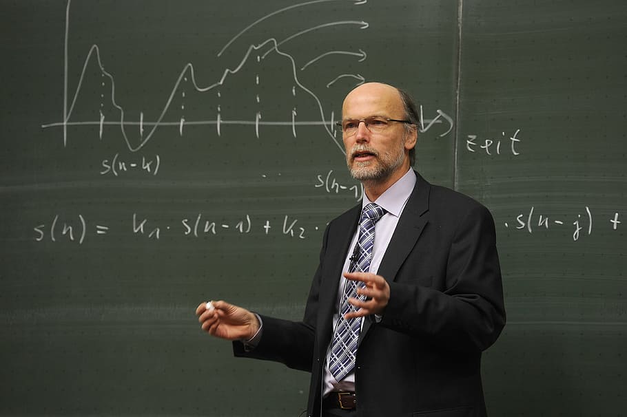 man wearing black suit jacket, birger kollmeier, professor, blackboard