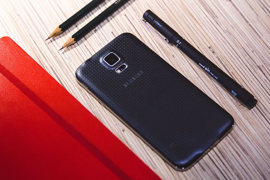 black Samsung Android smartphone beside black stylus pen and two pencils HD wallpaper