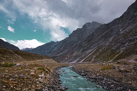 body of water near mountain at daytime, rocky mountain near the river photography HD wallpaper