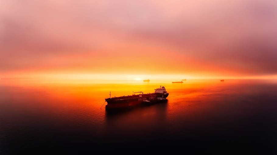 brown ship on body of water during golden hour, sunset, dusk