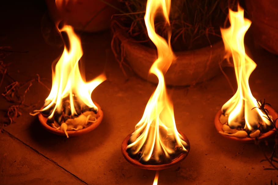 three lighted fire pits, diya, flame, ignite, burning diya, celebration