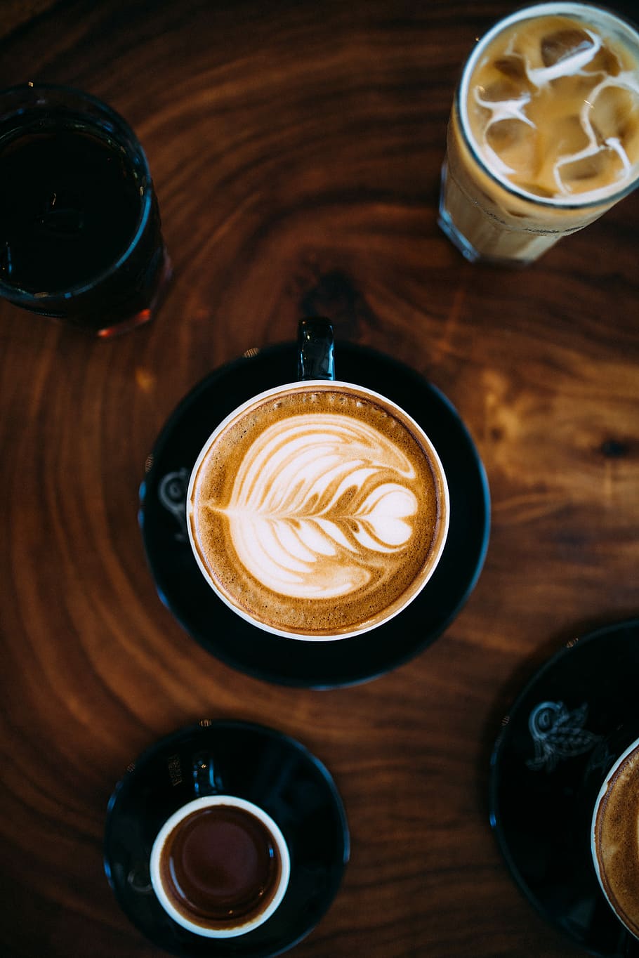 cup coffee with milk frothed on brown tabletop, flower designed latte HD wallpaper