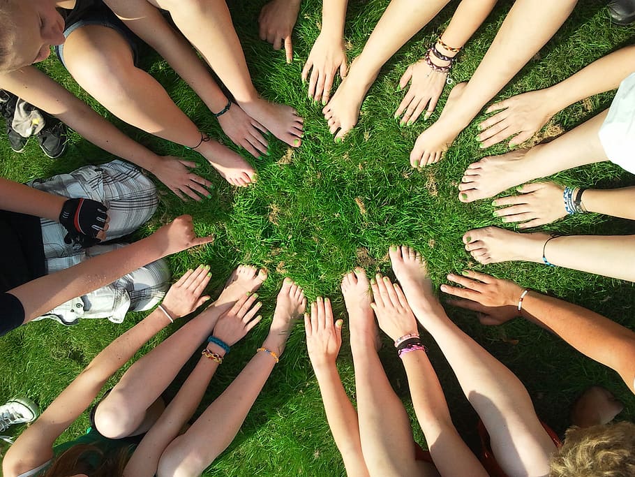 people hands and feet on green grass, team, motivation, teamwork