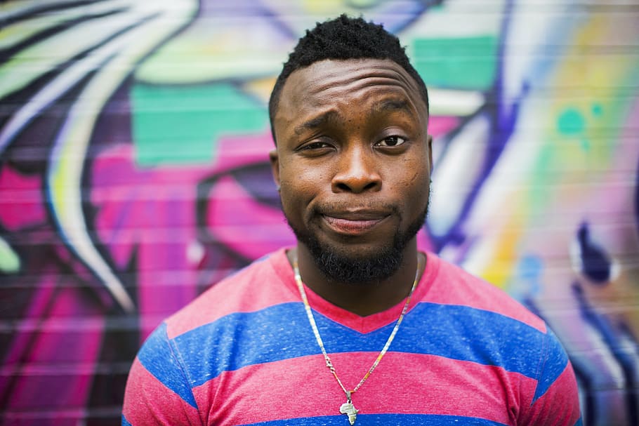 man wearing pink and blue stripe v-neck shirt with graffiti background HD wallpaper