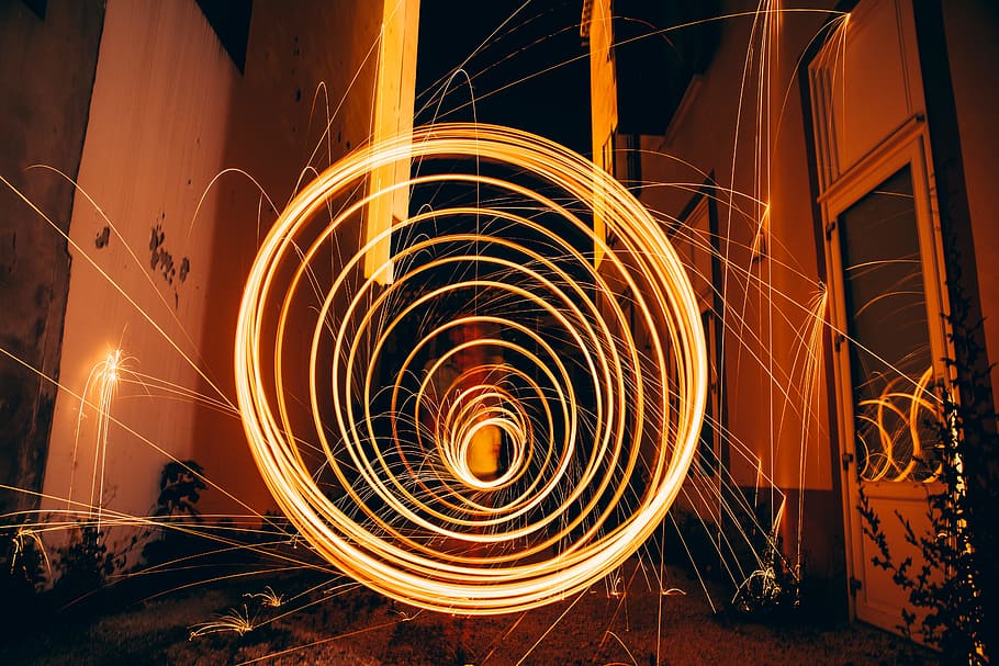 photo of swirling fireworks, brown Neon light time lapse photography