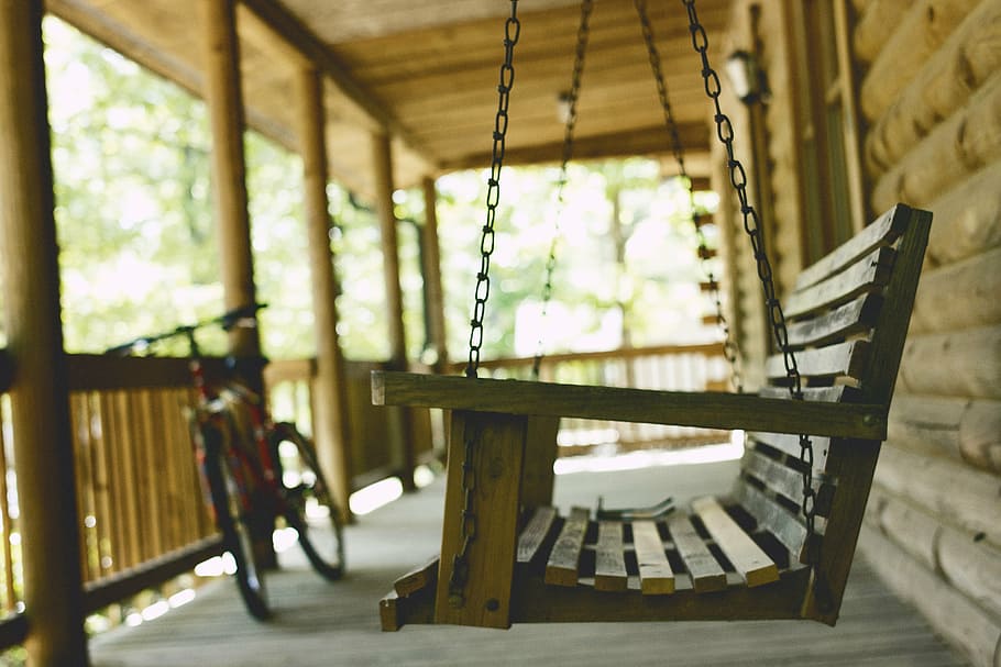 shallow focus photography of brown wooden swing bench, bicycle