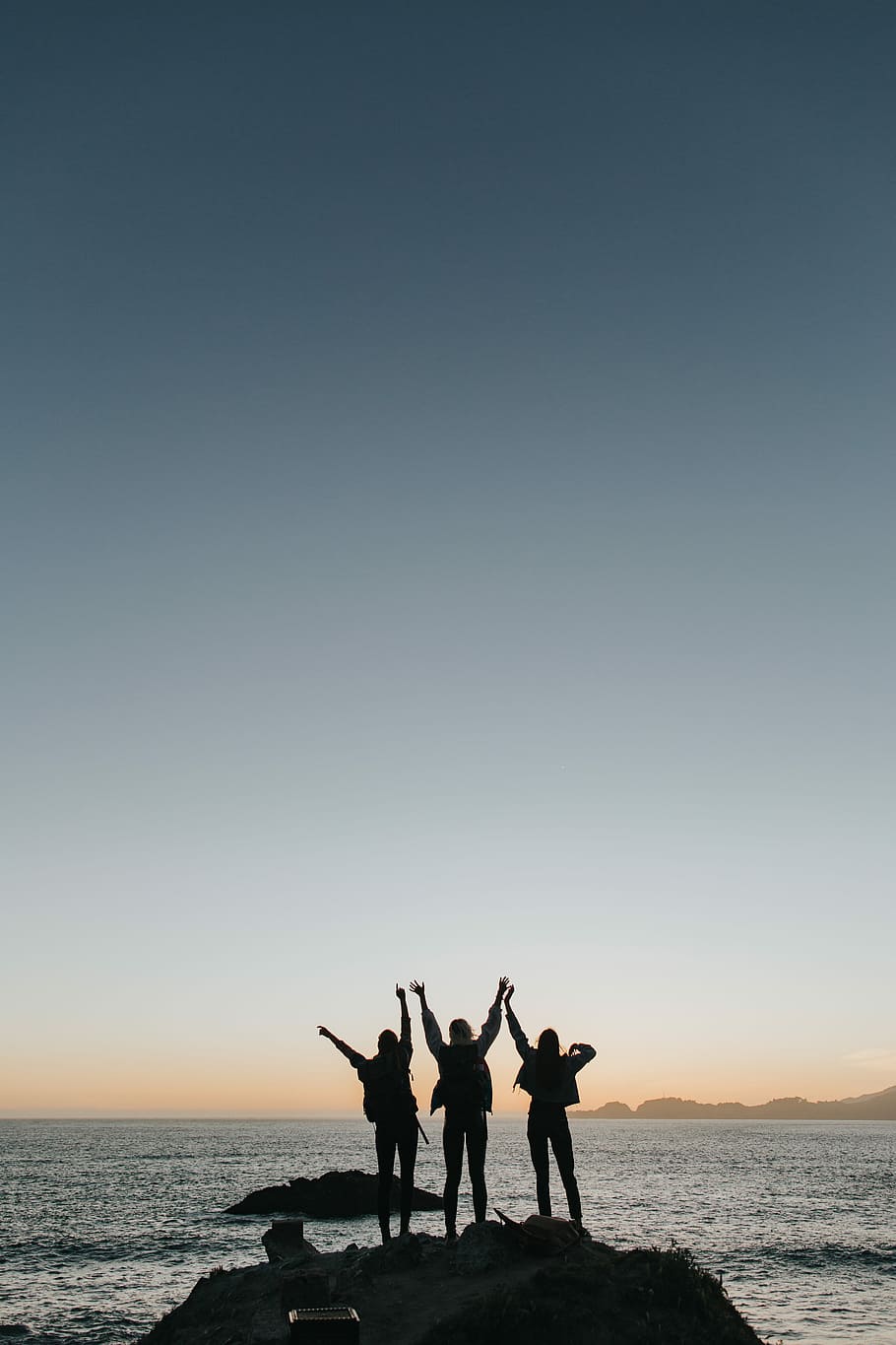 silhouette photography of persons raising hands while standing on island, three person standing near sea raising their hands HD wallpaper
