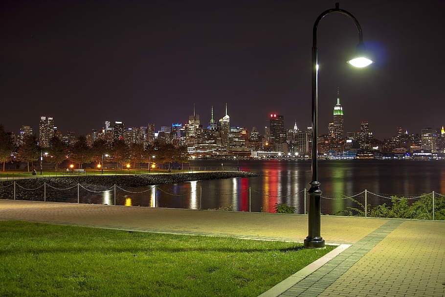 black lamppost with city building background during night, Nyc, New York