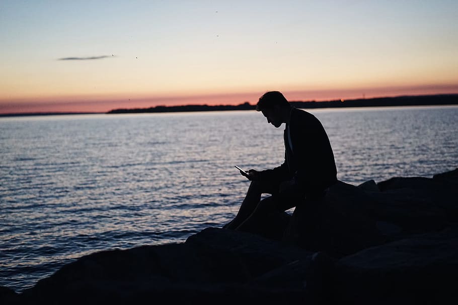 man sitting on rock in front of ocean, silhouette of man sitting near sea, HD wallpaper