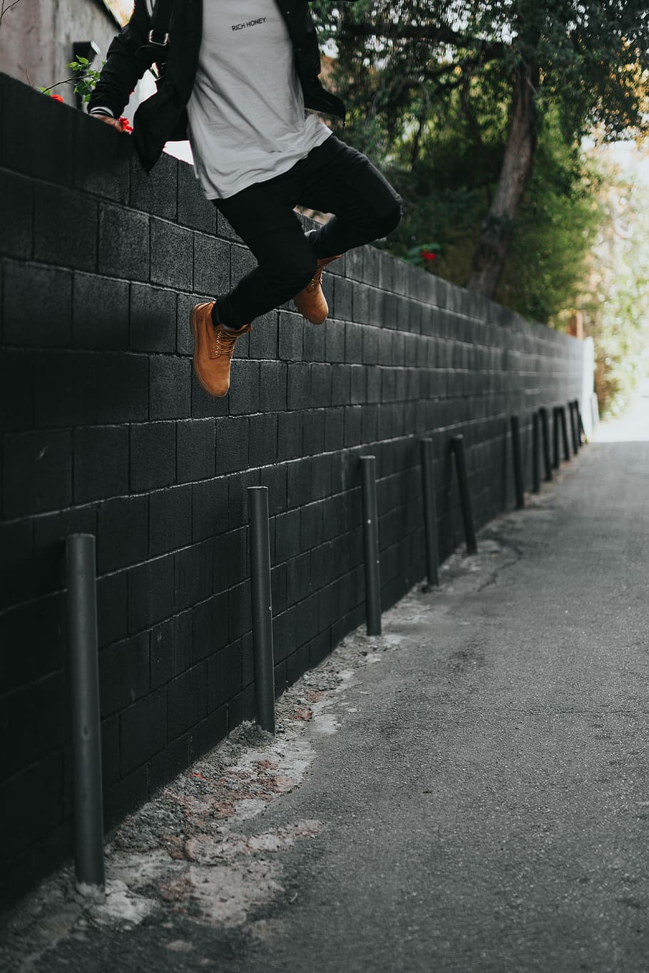 HD wallpaper: man jumping over fence, man jumping on black concrete fence, wall | Wallpaper Flare