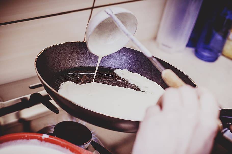 person holding pouring white cream using ladle on frying pan on stove, HD wallpaper
