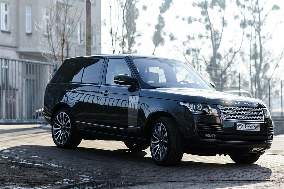 black Land Rover Range Rover SUV parked on pavement near fence and buildin HD wallpaper