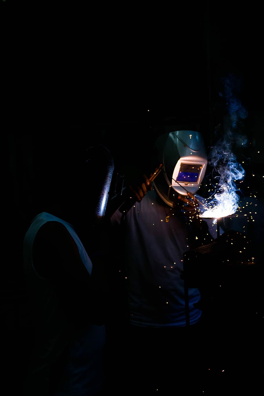 person wearing gray welding mask holding welding machine, welder